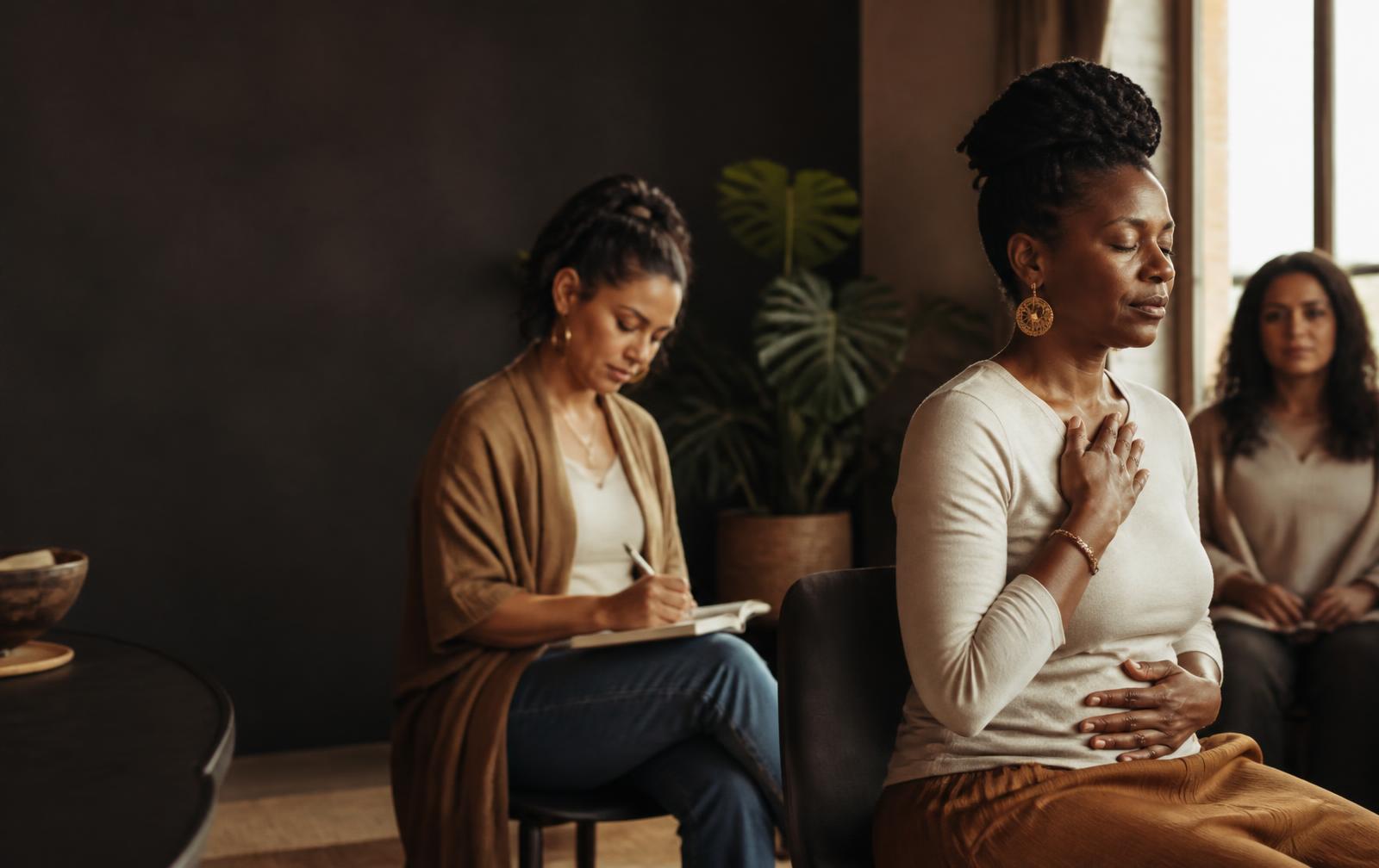 Women journaling and practicing a calming breath together